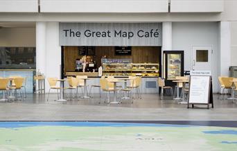 The Great Map Café, located inside the National Maritime Museum. In the picture you can see the café with a range of treats and lots of seating.