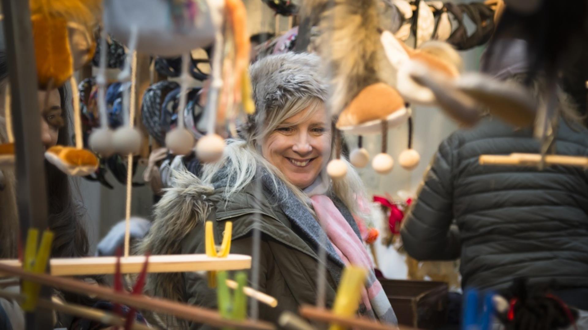 A woman looks at the gifts on a stall at Greenwich Market