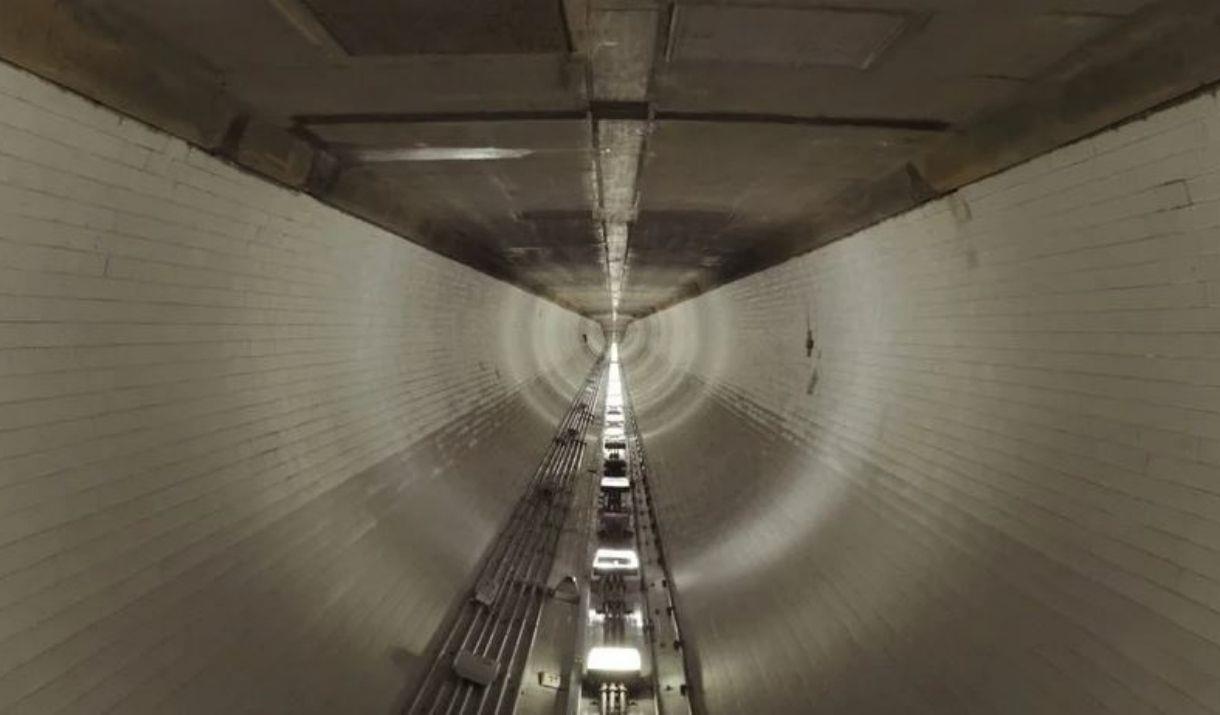 A group of singers perform whilst walking the length of Woolwich Foot Tunnel.