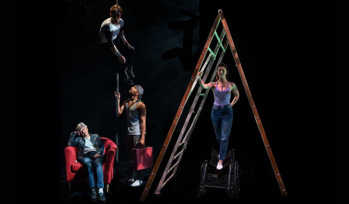 Four performers on a dark stage. The left half of the image is filled with a large ladder, under which a white woman in her thirties stands, balancing