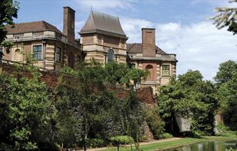 Art Deco mansion Eltham Palace surrounded by its beautiful, lush green gardens and moat.