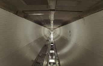 A group of singers perform whilst walking the length of Woolwich Foot Tunnel.