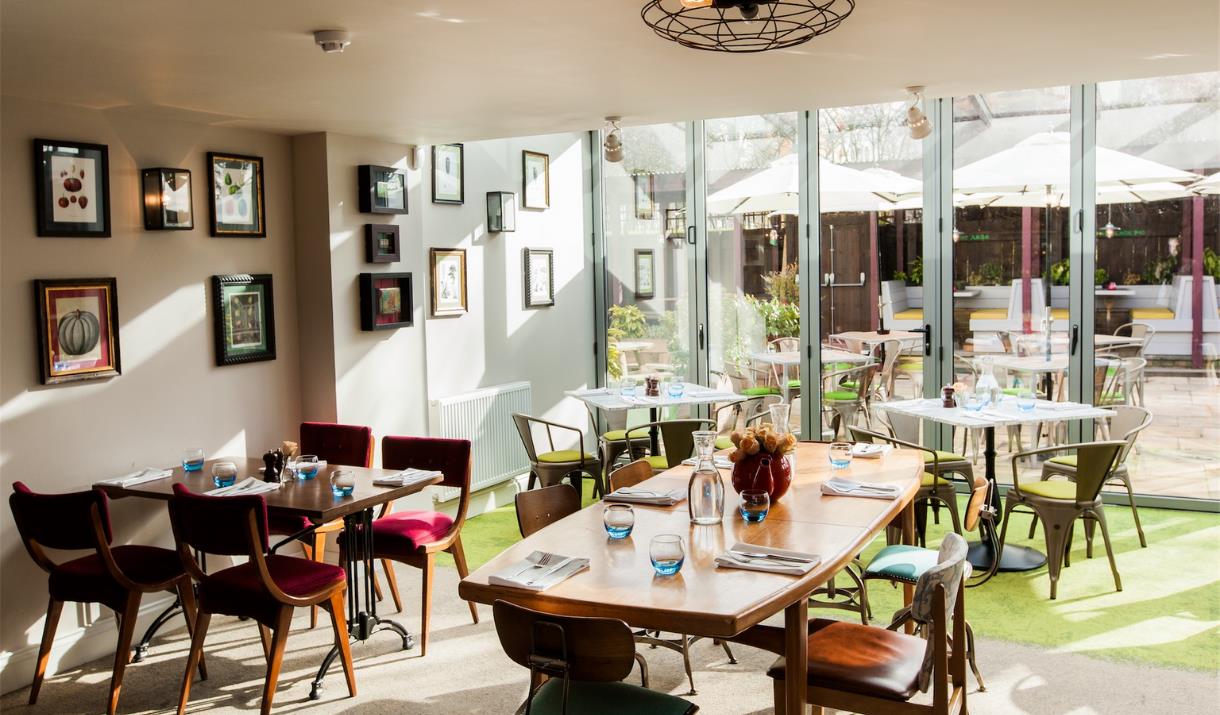 The dining room at The Pilot is bright and airy and overlooks the garden through floor to ceiling glass doors. The dining room at The Pilot is bright and airy and overlooks the garden through floor to ceiling glass doors.